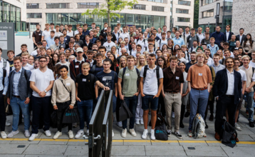 Das Bild zeigt eine Gruppe von etwa 100 jungen Studierenden auf dem Campus der BHH.