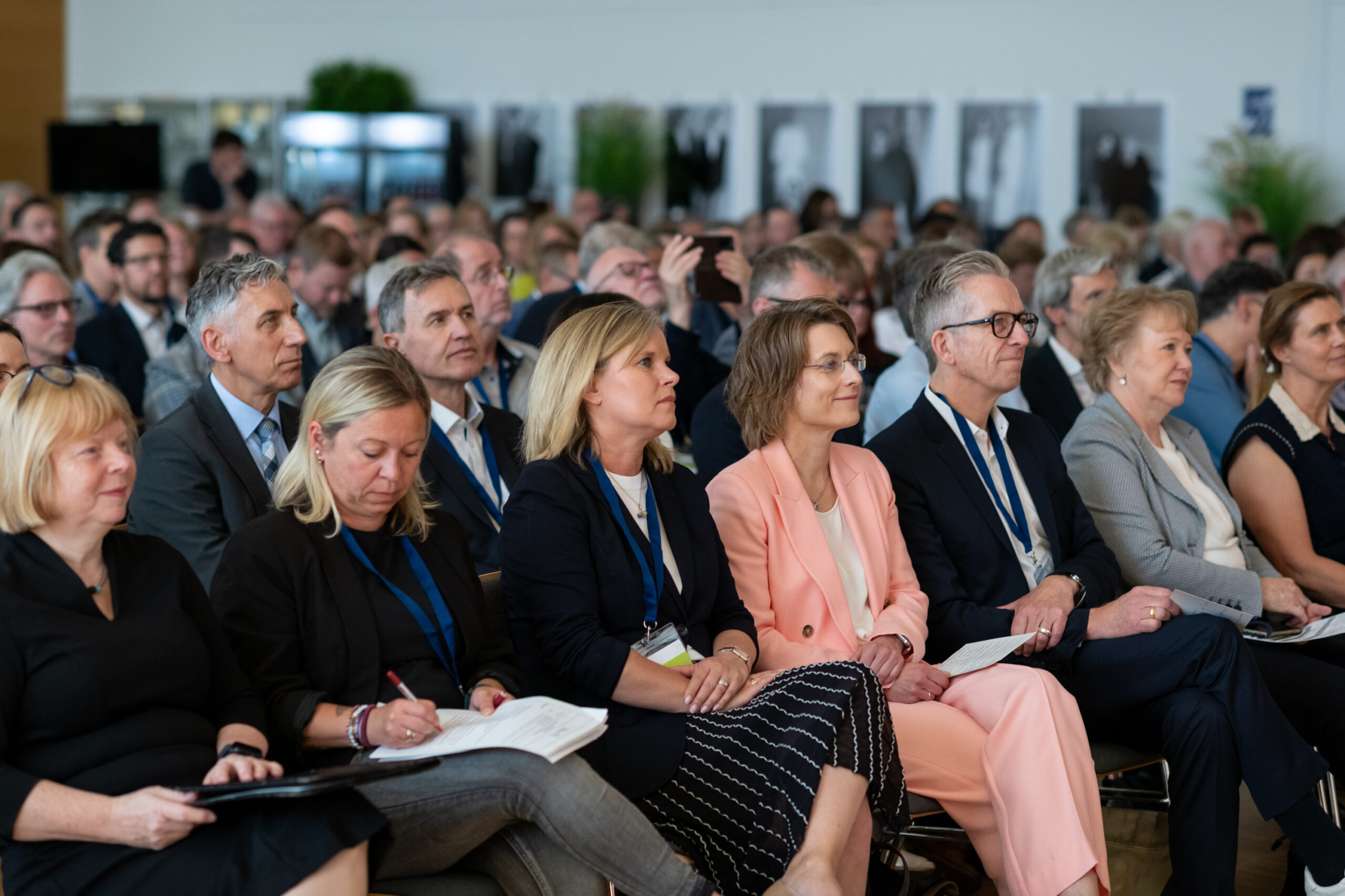 Viele Menschen sitzen in einer Aula und hören zu